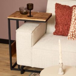 Houten bijzettafel naast beige bank met kussen, modern interieur design, warme woonstijl, hout en metaal, stijlvolle woonkamers, interieuraccessoires, woonkamer decoratie, functioneel meubel, stijlvolle woonideeën, warme woonstijl.
