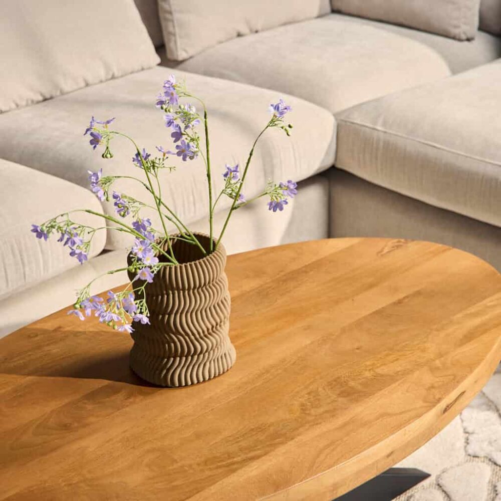 Elegante houten salontafel met natuurlijke afwerking geschikt voor moderne woonkamers, gecombineerd met een stijlvolle vaas en bloemen voor een gezellige sfeer.