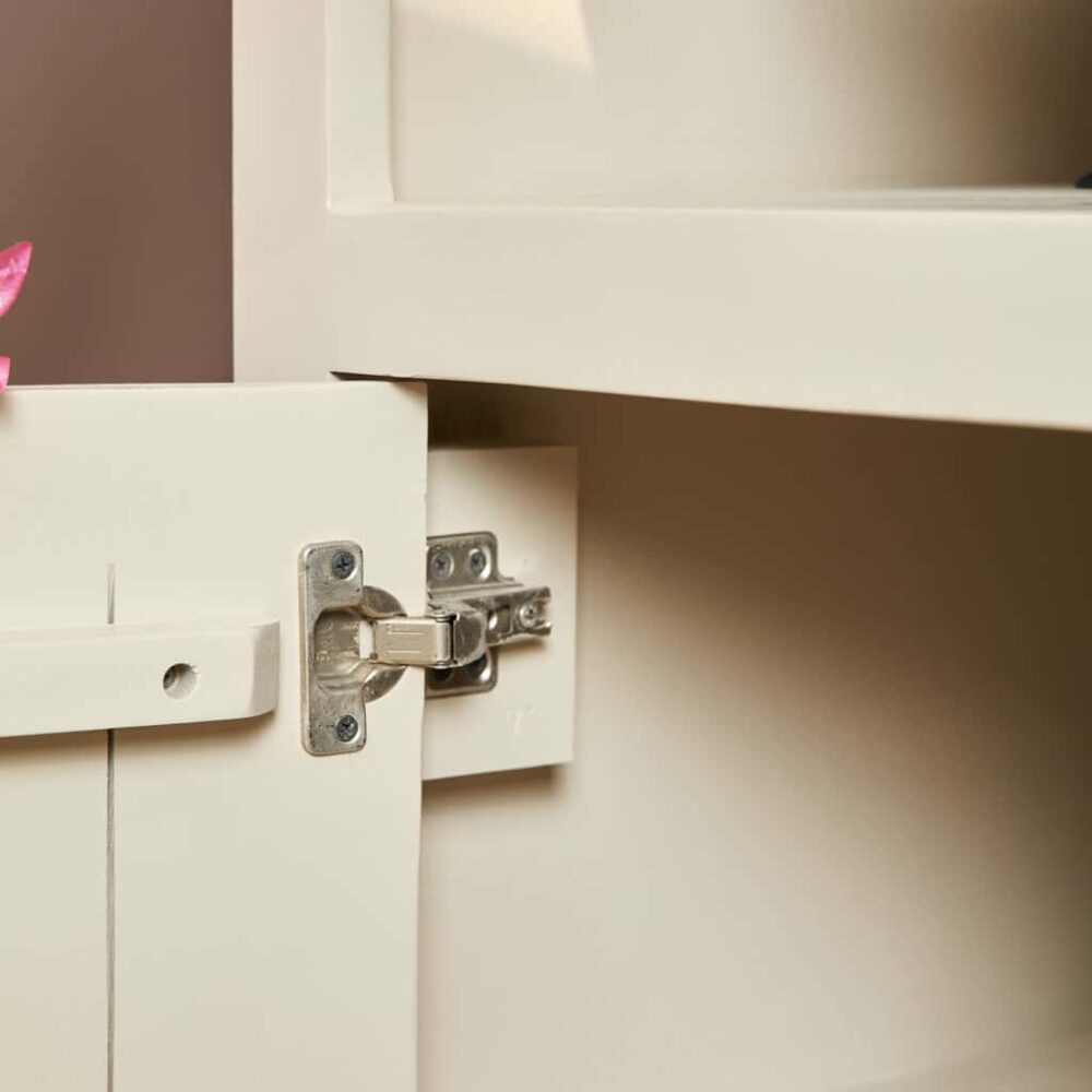 Gemonteerde white houten kastdeur met metalen scharnier.