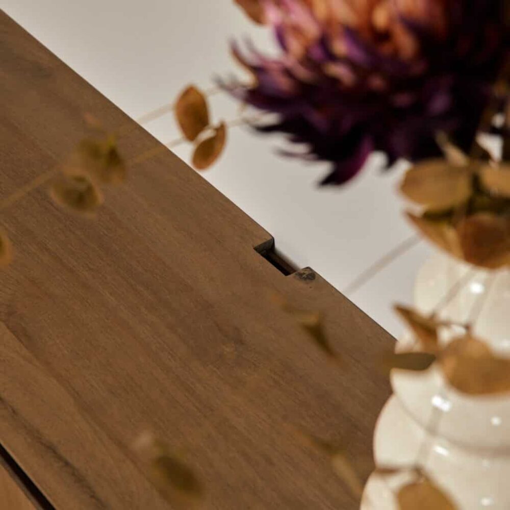 Modern houten tafel met zichtbaar houtstructuur en sierlijke bloemdecoratie, perfect voor een warme, natuurlijke sfeer in huis of kantoor.