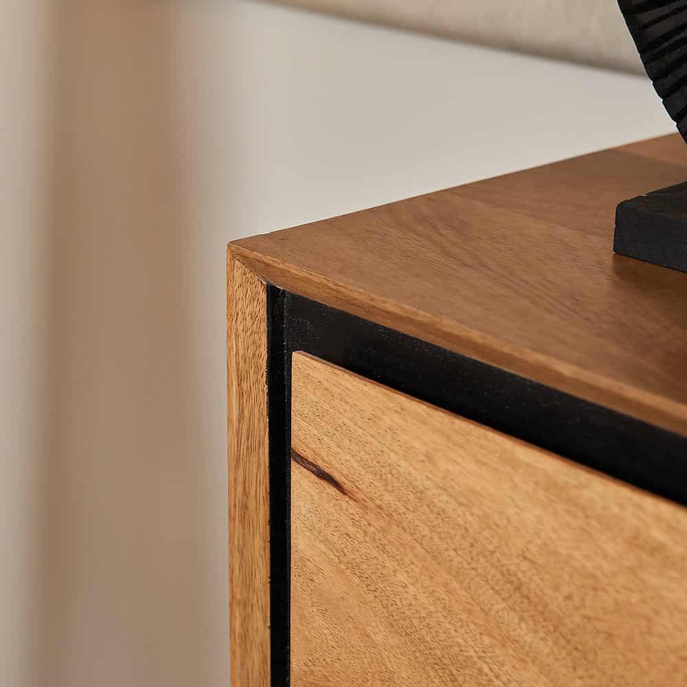 Minimalistische meubeldetails met natuurlijk houten afwerking en zwart metalen accenten, perfect voor een modern en warm interieur.