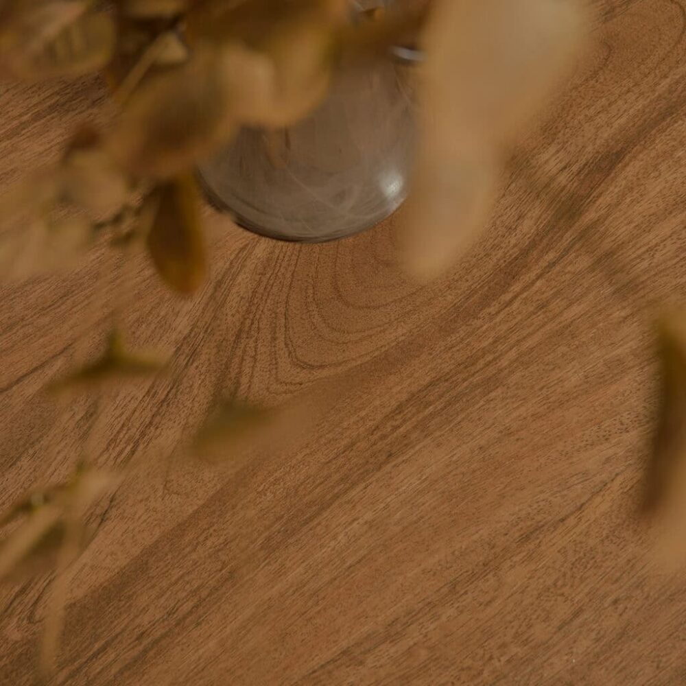 Natuurlijke houten tafel met een glazen vaas en decoratieve takken voor een warme, gezellige sfeer. Perfect voor stijlvolle woonkamer of eetkamer interieurs.