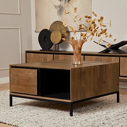 Strak houten salontafel met industrieel zwart metalen onderstel, modern in woonkamer met decoratieve vaas en uniek kunstwerk op achtergrond.