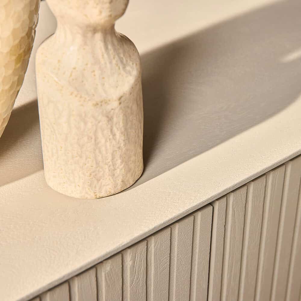 Rustieke beige vaas met textuur, decoratief op de houten kast.