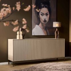Elegante houten sideboard met verticale lijnen, stijlvolle decoratie en moderne lamp op een beige muur.