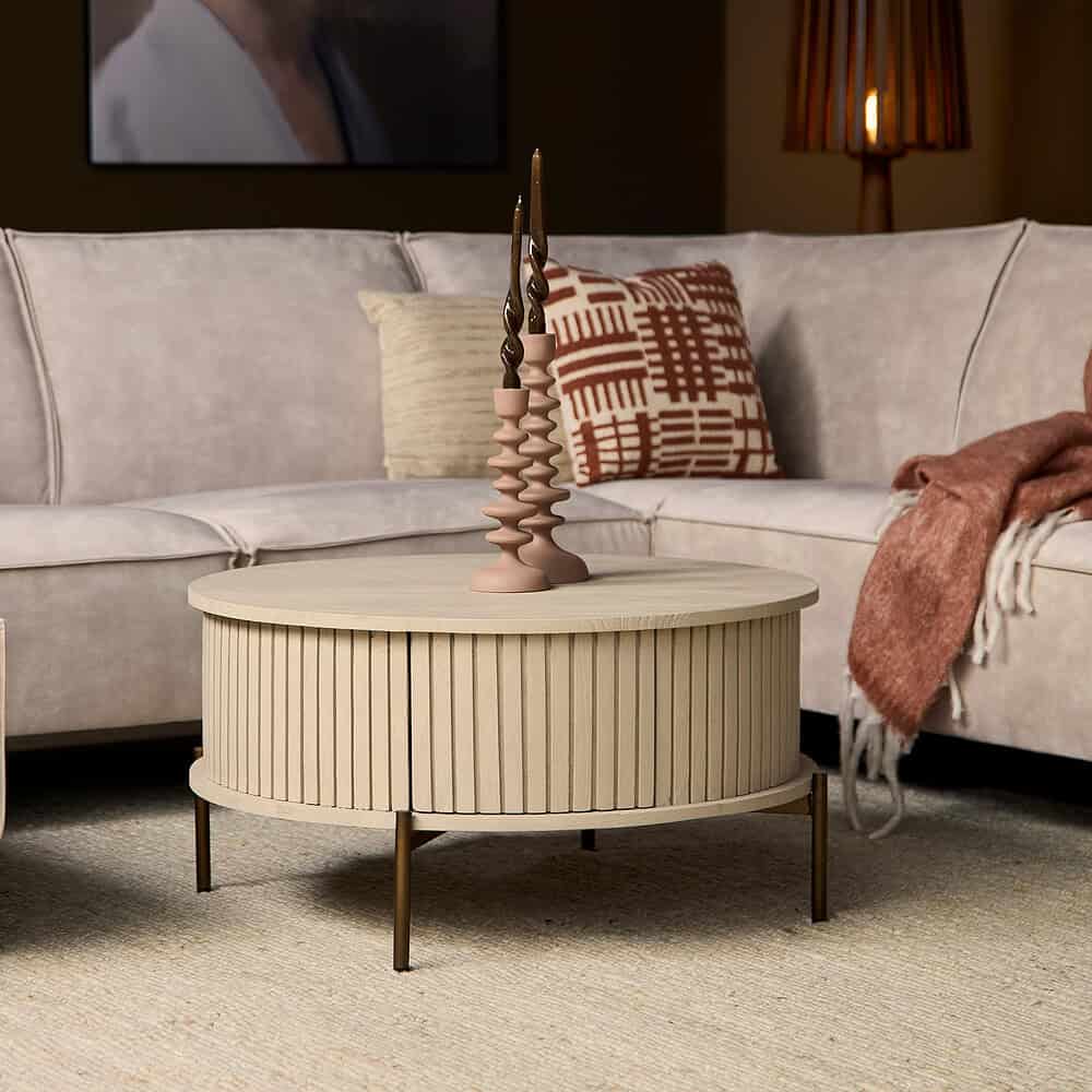 Houten rond salontafel met verticale groeven en metalen poten in een woonkamer setting.
