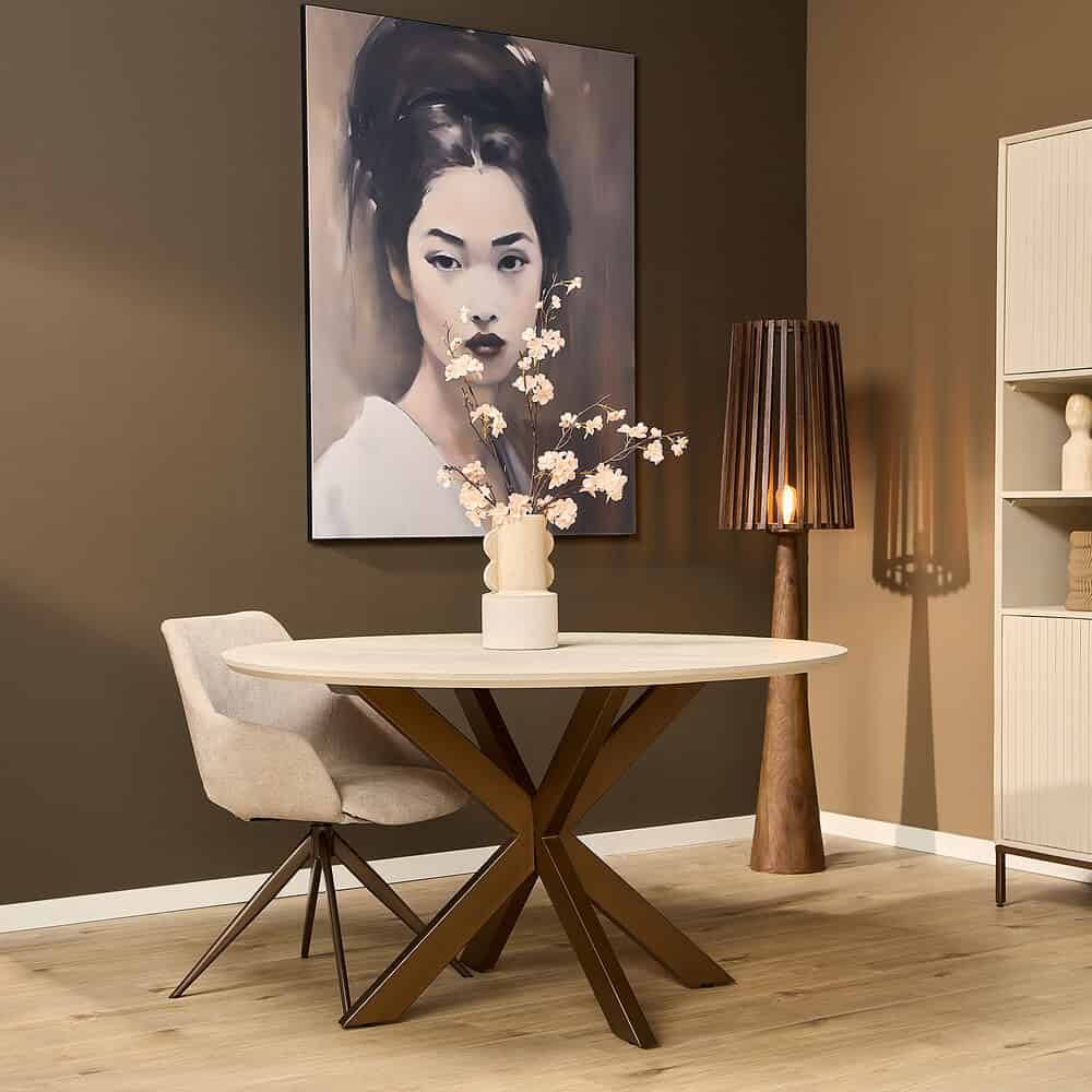 Elegant eettafel met moderne houten poten en een beige stoffen stoel, stijlvolle woonruimte decoratie met kunstwerk en sfeerverlichting voor een warme ambiance.