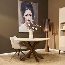 Moderne eetkamertafel met houten poten en een witte blad, gecombineerd met een comfortabele beige eetkamerstoel en sfeervolle houten vloerlamp, perfect voor stijlvolle interieurs.