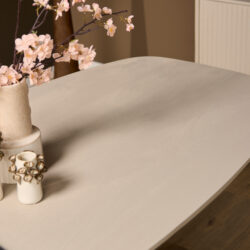 Zacht beige houten eettafel met bloemenvaas en decoratief servies, in een modern wooninterieur, perfect voor eetkamer of design interieurs, hoogwaardige natuurlijke materialen, op maat gemaakt by Mokana Meubelen.