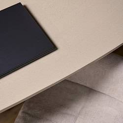 Strak zwart toetsenbord op beige houten bureau met textuurrijke afwerking, modern en minimalistisch design.