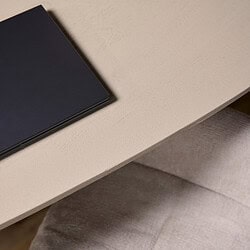 Minimalistisch zwart notitieboek op een licht beige bureau.