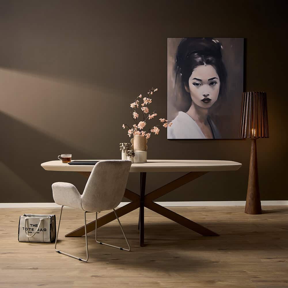 Elegante eettafel met moderne, houten onderstel en wit blad, gecombineerd met comfortabele fauteuil en stijlvolle decoratieve accessoires voor een sfeervol interieur.