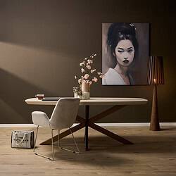 Elegante eettafel met moderne, houten onderstel en wit blad, gecombineerd met comfortabele fauteuil en stijlvolle decoratieve accessoires voor een sfeervol interieur.