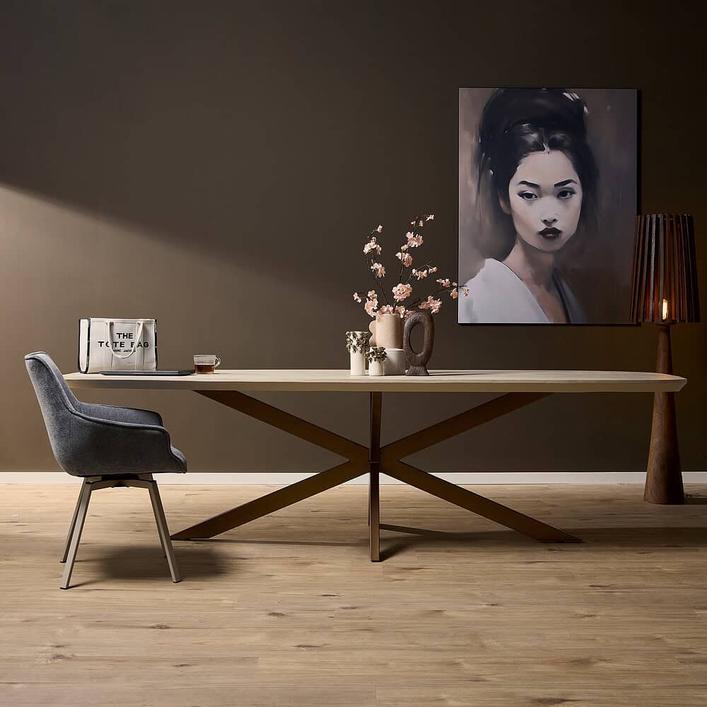Elegante eettafel met moderne design van Mokana Meubelen, gecombineerd met een stijlvolle fauteuil, kunstglaswerk en een opvallende portret schilderij voor een verfijnde interieurstijl.