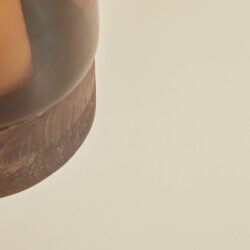 Kleine close-up van een houten meubel met een roestbruine afwerking, zichtbaar verdeeld in gekleurde segmenten, op een lichte achtergrond. Perfect voor meubelontwerp, houten meubels en design inspiratie.