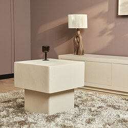 Strak wit bijzettafel in modern woonkamer met blush muur en houten lamp, stijlvol en functioneel.