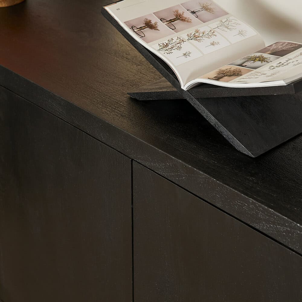 Strak afgewerkte houten kast met open boek met botanische prints, stijlvolle meubelstuk van Mokana Meubelen voor een moderne en natuurlijke uitstraling.