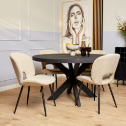 Stijlvolle eettafel met zwarte onderstellen en beige geweven stoelen, modern interieur met kunstwerk en decoratieve accessoires.