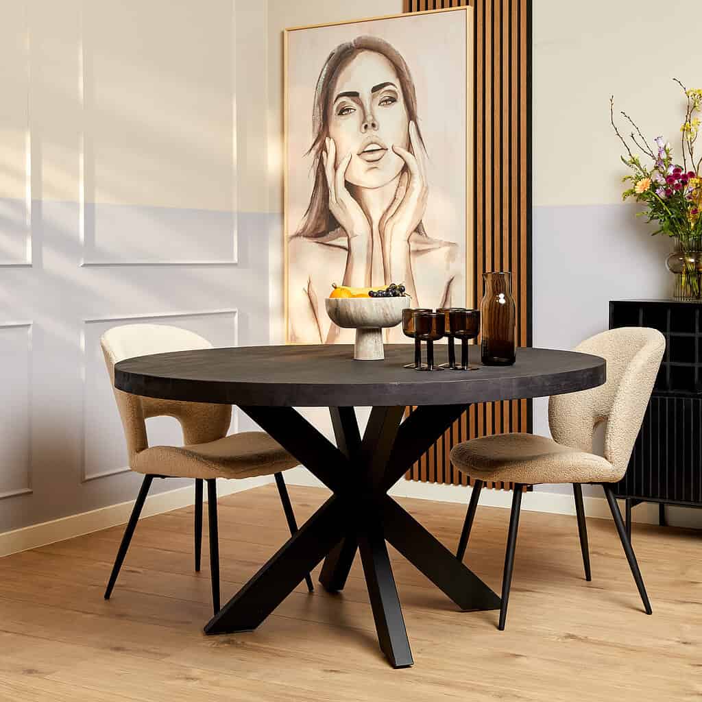 Krachtige zwarte eettafel met sculpturale poten in een modern eetkamerinterieur.