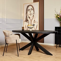 Modern eettafel in zwart gebeitst hout met unieke kruisvoet, passend bij eigentijdse interieurstijl.