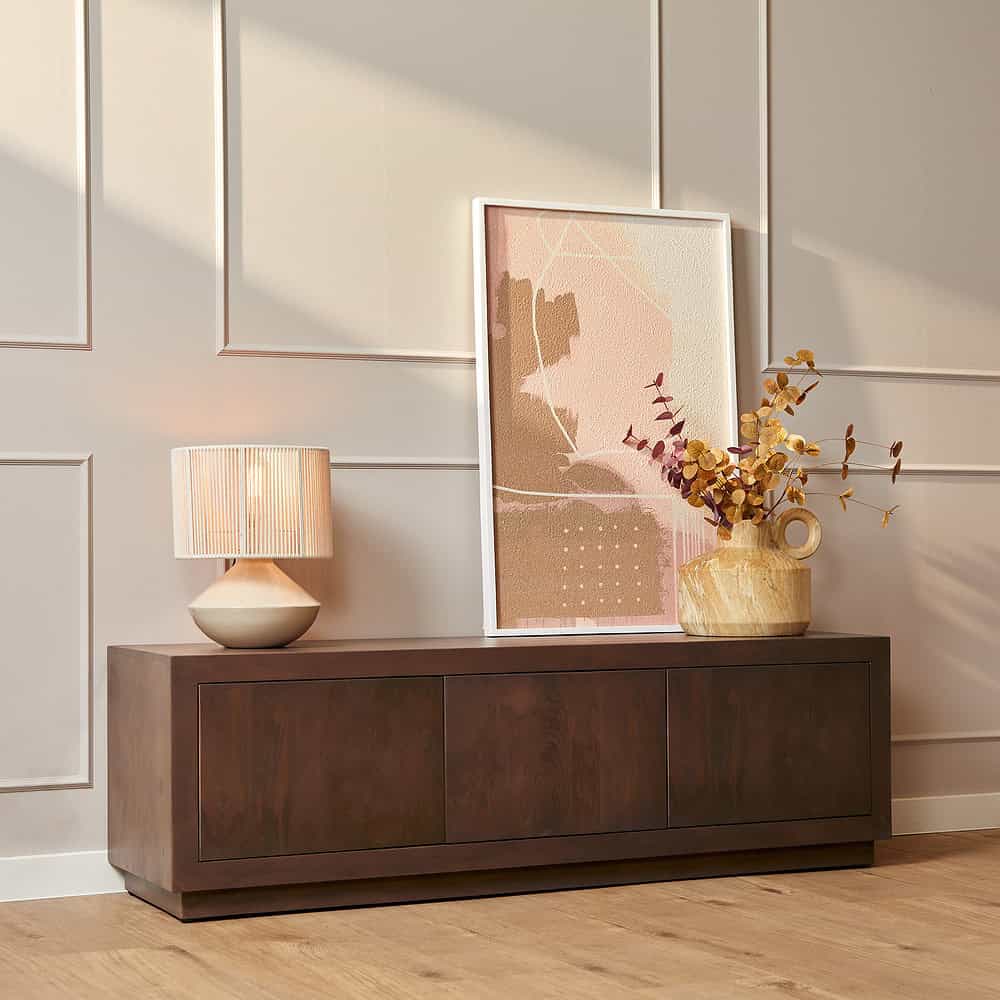 Elegant houten dressoir met opbergkasten in een modern interieur, perfect voor het opbergen en presenteren van decoratieve items.