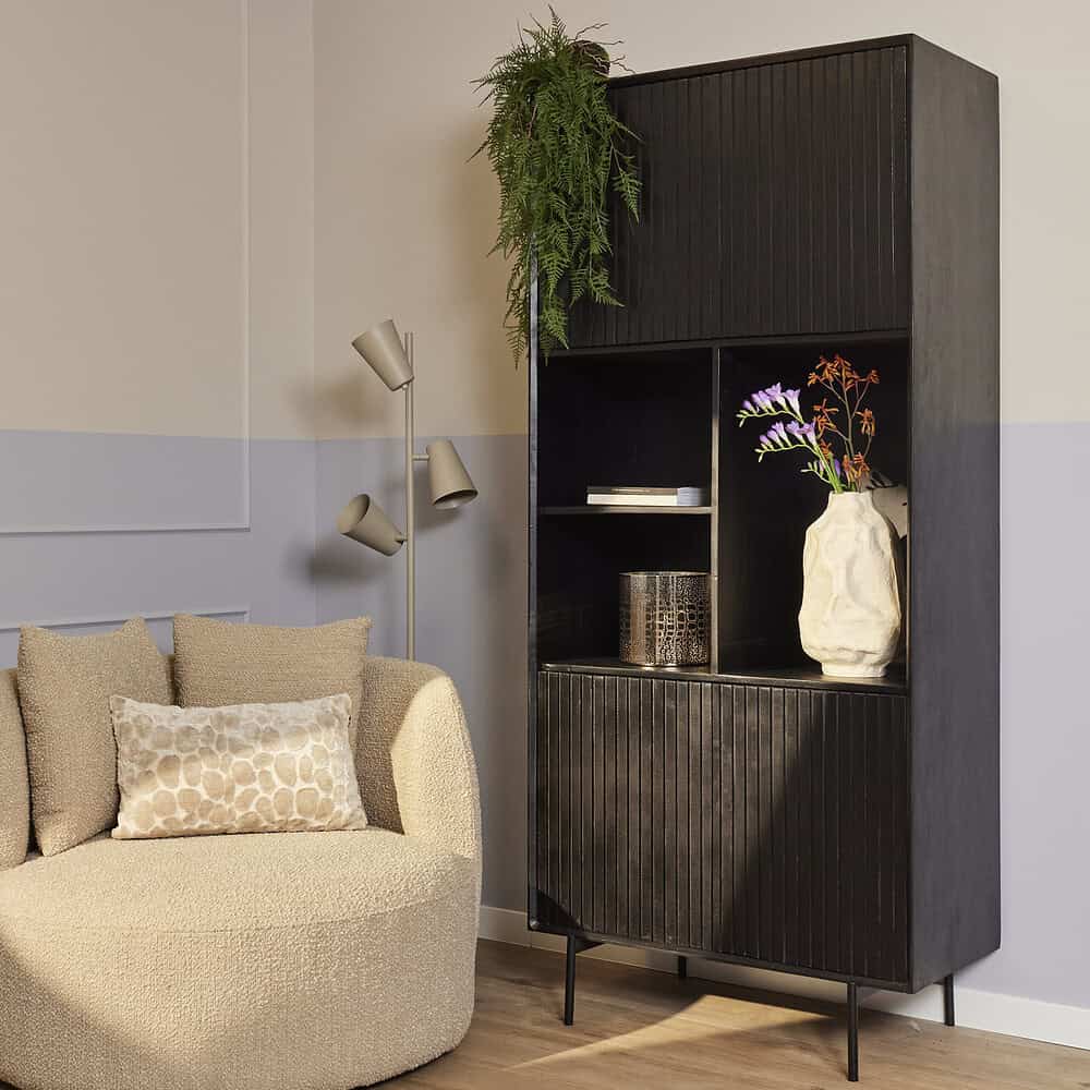Vintage houten boekenkast met opbergvakken en decoratieve accessoires voor een stijlvolle woonkamer.