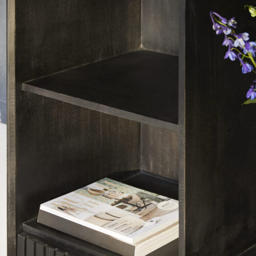 Zwarte houten boekenplank met opgerolde tijdschrift en paar blauwe bloemen, modern design, woondecoratie, elegante meubelstukken, stijlvolle interieuraccessoires.