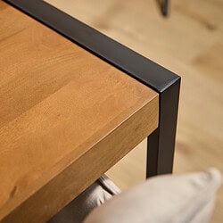 Elegante eettafel met massief houten blad en zwart metalen frame, perfecte combinatie van natuurlijk en industrieel design.