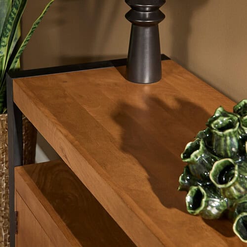 Warm eikenhouten bijzettafel van Mokana Meubelen met zwart metalen frame, perfect voor een stijlvolle woonruimte, gecombineerd met decoratieve accessoires voor een modern landelijke uitstraling.