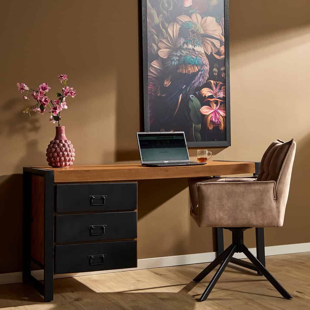 Efficiënt bureau met houten blad en zwarte lade, gecombineerd met comfortabele beige bureaustoel voor thuiswerkplezier. Mooie muurdecoratie en decoratieve vaas met bloemen voor een stijlvolle werkplek.