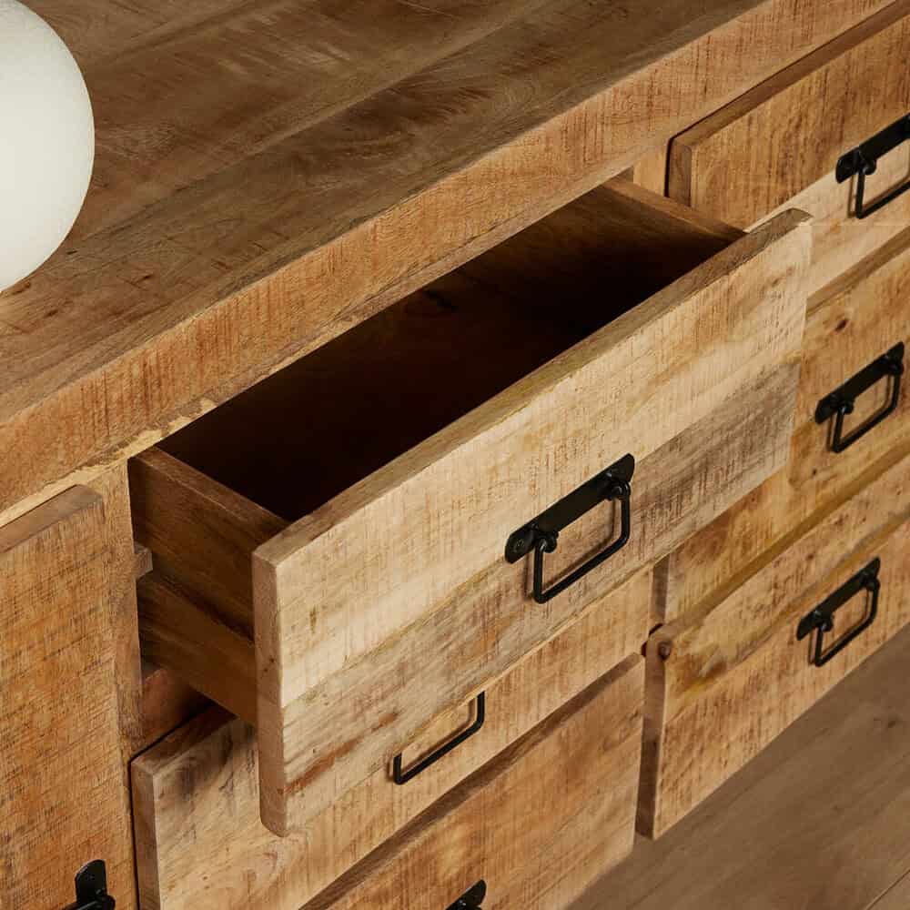 Robuuste landelijke houten kast met open lade en zwarte metalen handvatten, perfect voor opbergruimte en decoratie in huis.