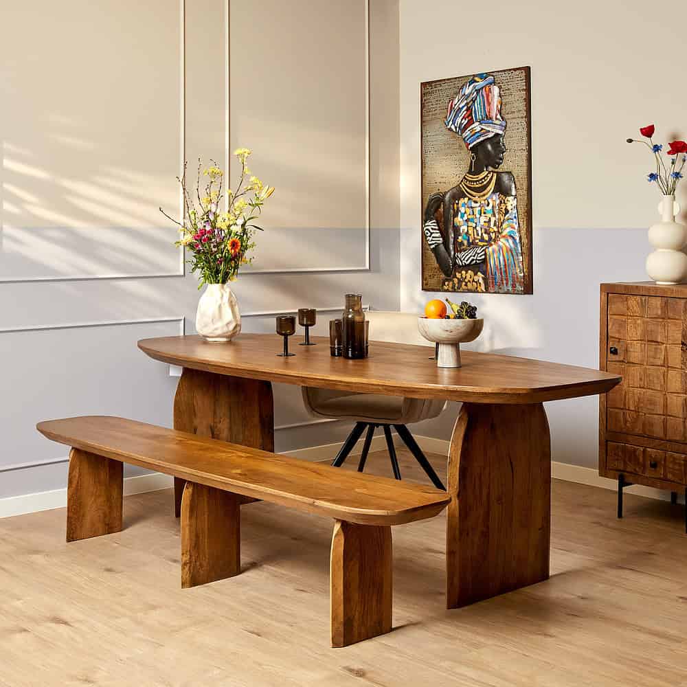 Eetkamer met leefstijltafel in massief hout, houten bank en moderne decoratie, stijlvolle woonruimte met Zeeuws meubelontwerp en natuurlijke materialen.
