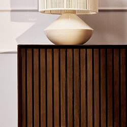 Houten meubel met verticale lamellen en witte tafelklok op donkerhouten bedside table, modern en minimalistisch design.