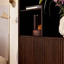 Groteelijke donkere houten boekenkast met verticale groeven en decoratieve accessoires, perfect voor modern interieur.