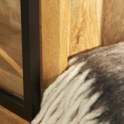 Houten meubel met metalen frame en wollige deken op de vloer, focus op natuurlijke materialen en modern design.