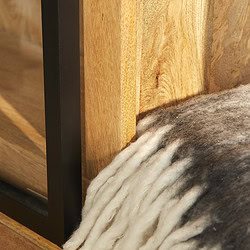 Houten meubel met zwart metalen frame en zachte wollen deken, duurzame meubelkwaliteit, moderne design, ambachtelijk vakmanschap, comfortabele woonstijl.