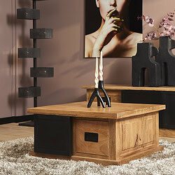 Houten salontafel met zwarte metalen accenten, gecombineerd met stijlvolle decoratie en moderne kunst in een woonkamer.