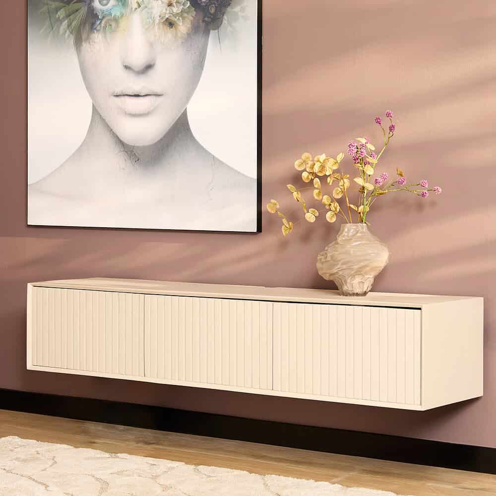 Strakke witte wandmeubel van Mokana Meubelen met verticale lamellen, geplaatst onder een moderne kunstprint en versierd met een bloemenvase, ideaal voor eigentijdse woonruimtes.