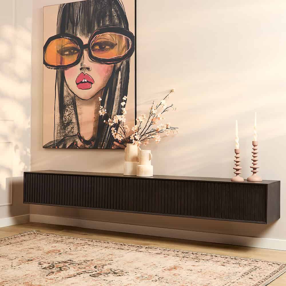 Strakke zwarte wandmeubel met geribbelde deuren voor een moderne woonkamer.