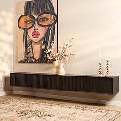 Strakke zwarte wandmeubel met geribbelde deuren voor een moderne woonkamer.