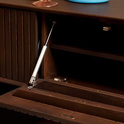 Houtbewerkingspaneel met gasdrukveer voor verstelbare kastdeuren, gemaakt van donker hout.