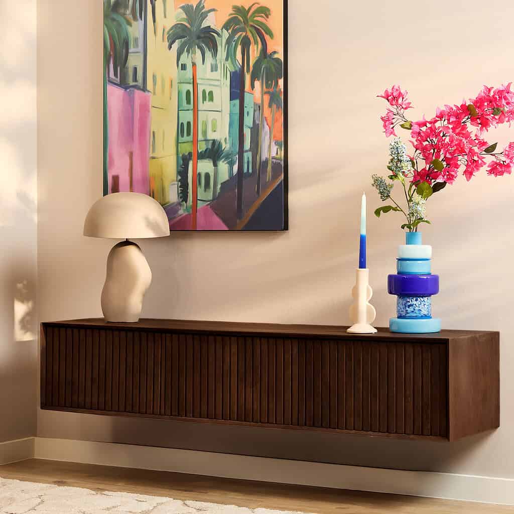 Elegante houten wandkast met verticale lamellen, decoratief interieur met bloemenvazen, kandelaars en kunstwerk in modern woonruimte.