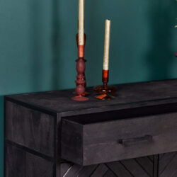 Stijlvolle zwarte houten dressoir met lade, decoratief met uniek gevormde sierkaarsen op een elegante groene muur achtergrond.