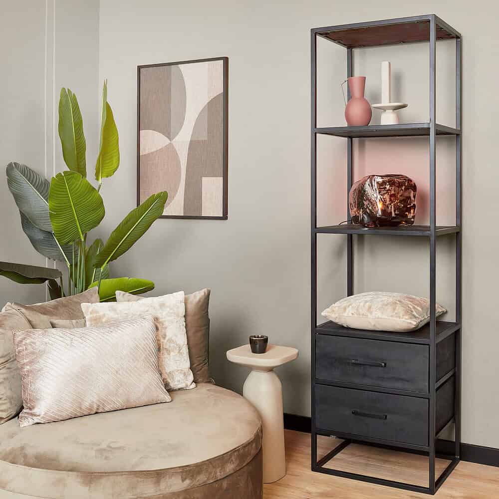 Vintage industriële metalen etagère met opbergladen en decoratieve items in een modern woonkamer.