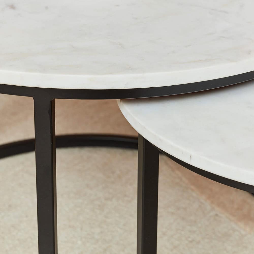 Ronde marmeren bijzettafel met zwart metalen frame, elegant en functioneel design, perfect voor modern interieur.