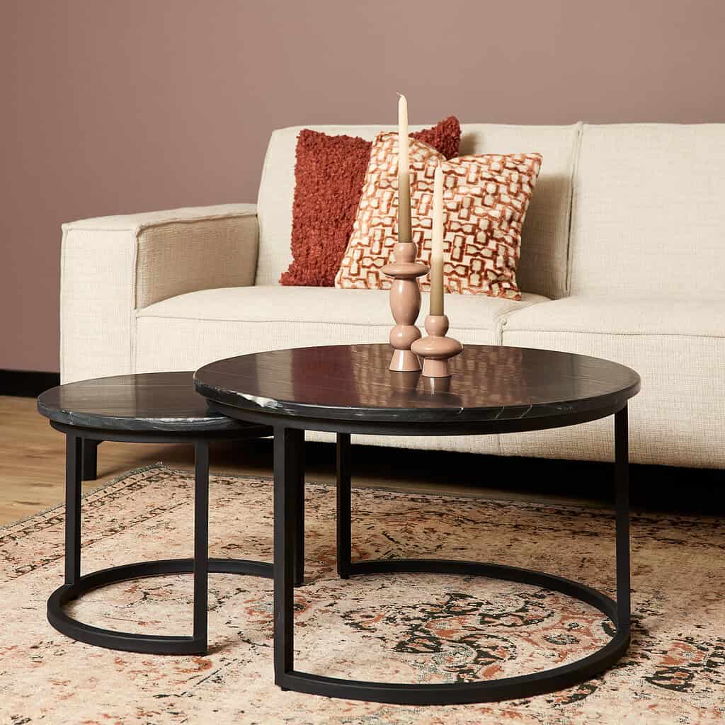 Handgemaakte, moderne salontafels in zwart eikenhout, perfect voor een stijlvol interieur met warme tinten en decoratieve kandelaars.