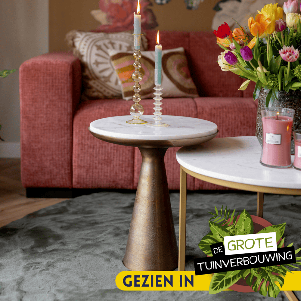 Vintage marmeren salontafel met goudkleurige voet, stijlvol in woonruimte met roze bank en bloemen, perfecte mix van modern en elegant design voor je interieur.