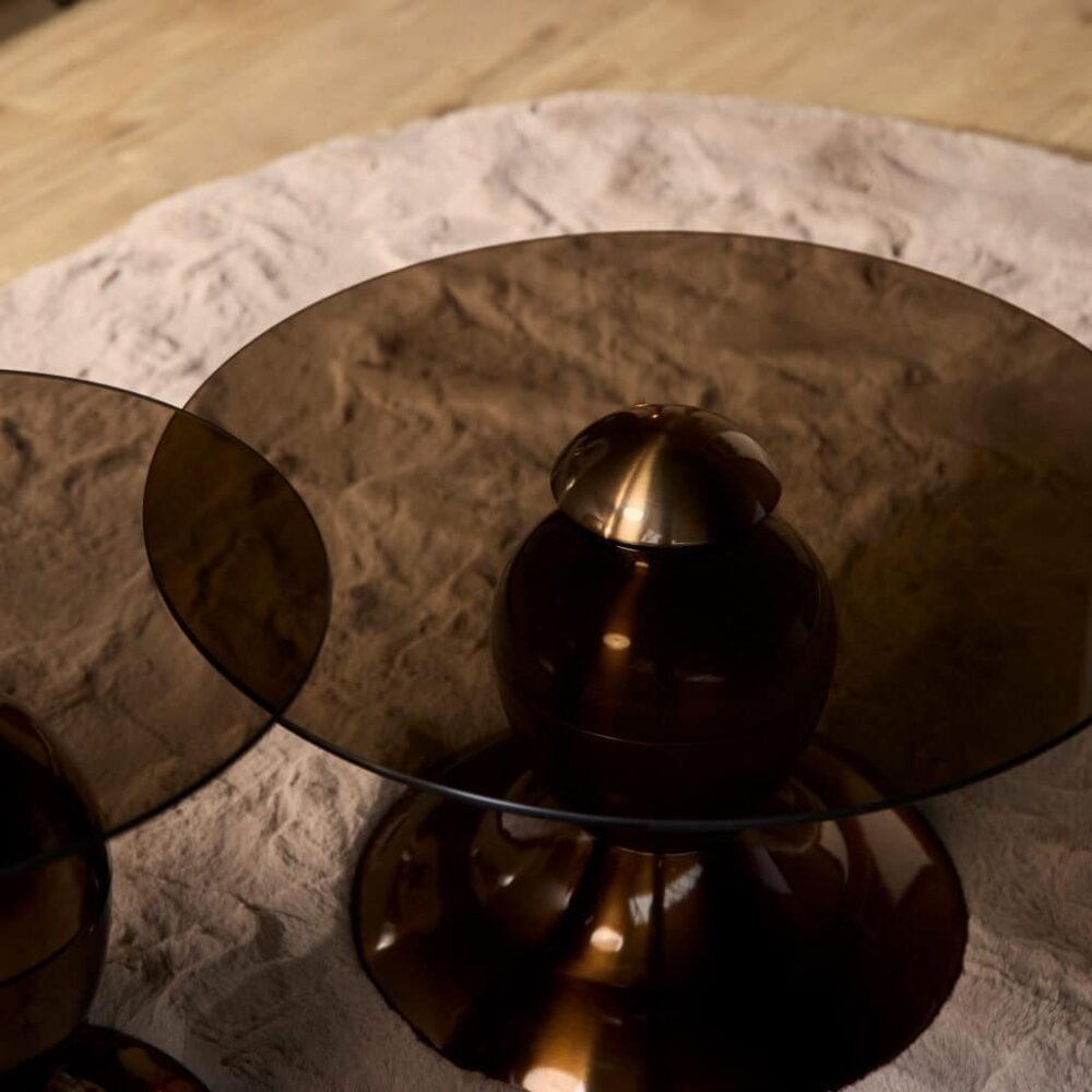 Strak design salontafel met glazen blad en goudkleurige basis, elegant meubelstuk voor modern interieur.