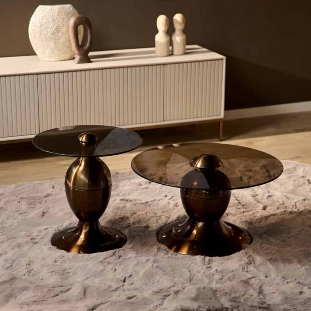 Elegant centrale salontafels met glanzend bronskleurig metalen onderstel en ronde glazen bovenkant, perfect voor moderne interieurdecoratie.