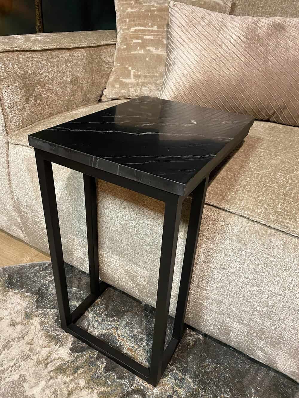 Strak zwart marmeren salontafel met open vierkante metalen frame, perfect voor modern interieur en luxe woonkamer.